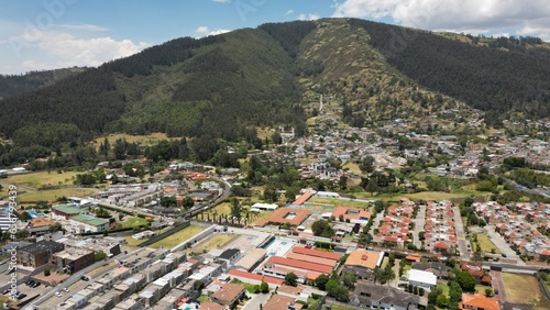 Aerials hot of Ilalo Mountain near Quito city, with lots of houses, sunny day.