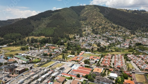 Aerials hot of Ilalo Mountain near Quito city, with lots of houses, sunny day. photo