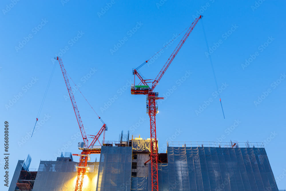 crane in construction buliding site at blue twilight evening sky