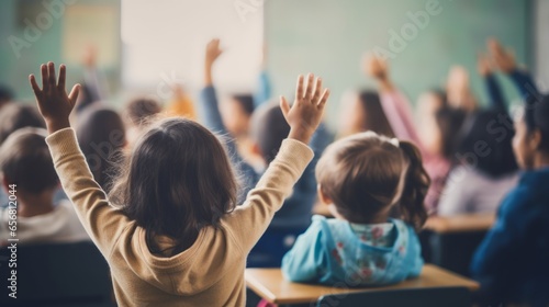 Children raising their hands in the classroom to help their academic education photo