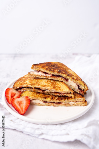 French toast with creme cheese, jelly and strawberries. 