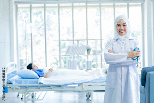 Asian muslim woman doctor working with smiling and freshness together to takecare ill patient in hospital. photo