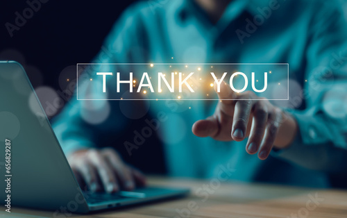 businessman using a laptop and touching the message thank you on a display screen. concept of thank you business, congratulations, and appreciation gratitude. presentation from technology digital