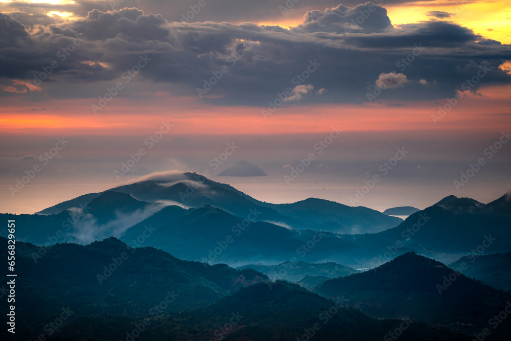 Obraz premium Watching the sunrise on the high mountains, far away is the famous coastal tourist city of Nha Trang