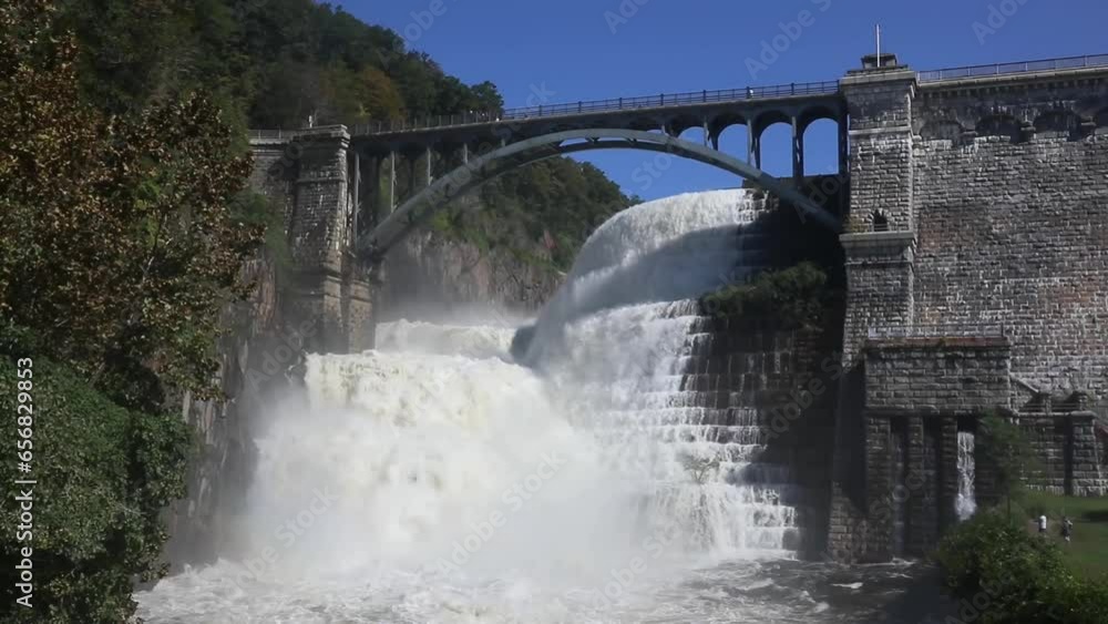 water flowing from the croton dam (heavy flow of water after strong rains) waterfall with bridge in westchester, upstate new york water flowing from the croton dam (heavy flow of water after strong rains) waterfall with bridge in westchester, upstate new york