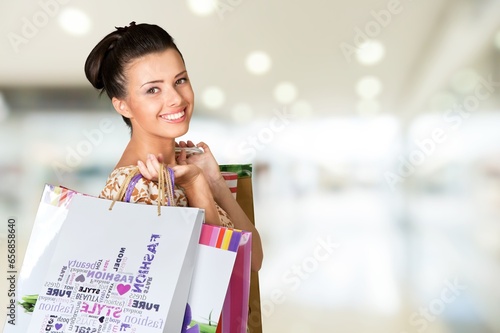 Cheerful young woman with a lot of shopping bags.