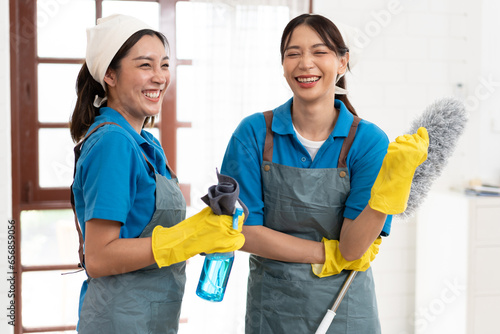 Foto Portrait two Asia woman in workwear maid cleaning home and holding dusting brush