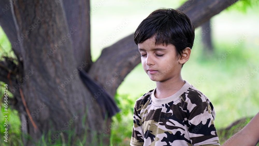 An indian boy doing yoga outdoors . Healthy and peaceful lifestyle An indian boy doing yoga outdoors . Healthy and peaceful lifestyle