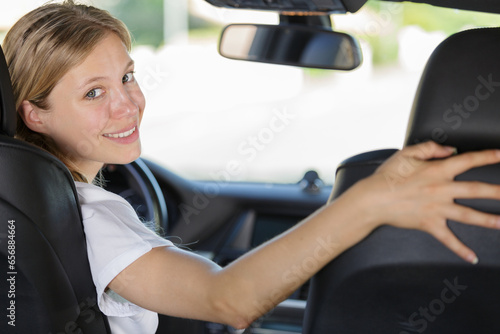 young woman driver inside car looking back © auremar