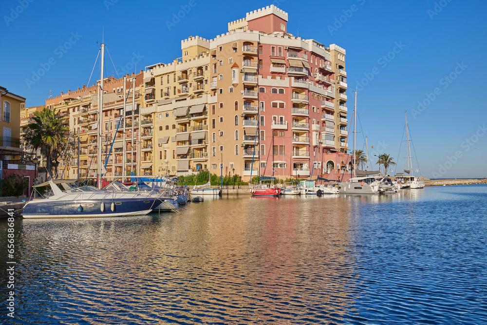 Panoramic view of colorfull houses and moored yachts in Port Saplaya. Houses and boats reflected in the water. Valencia's Little Venice.