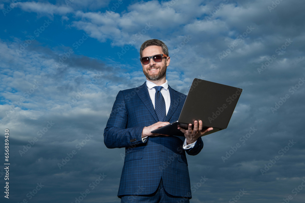Professional man using laptop. Professional businessman in suit. Successful ceo smiling in professional wear