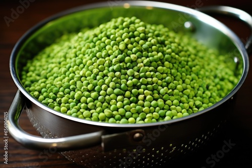 hand-shucked peas in a metal colander