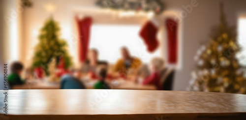 empty wooden table with beautiful out of focus family celebrating on christmas day photo