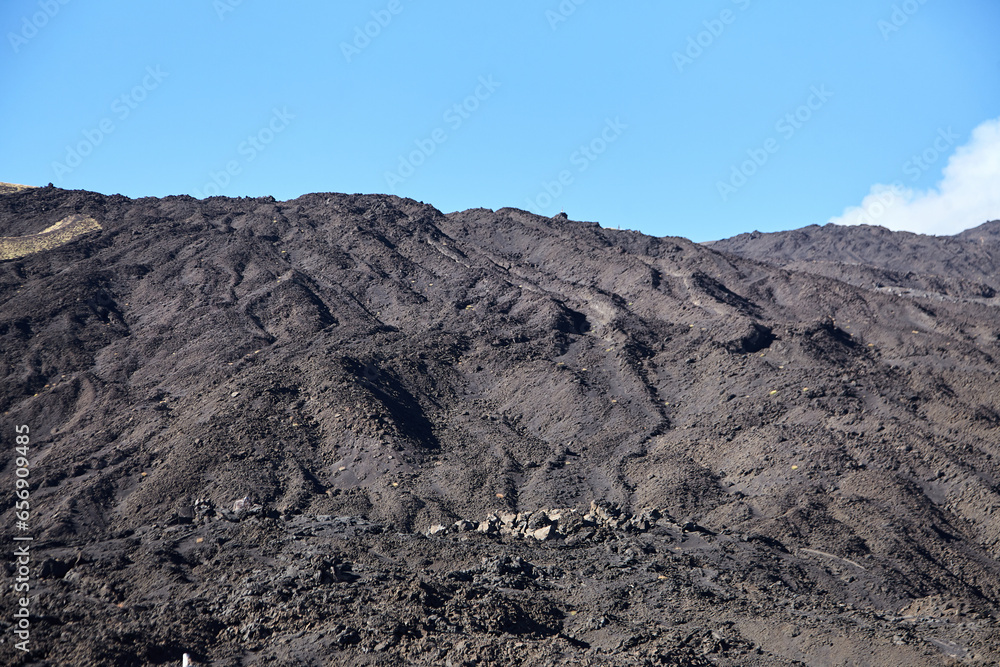 Mount Etna, Sicily, Italy. Slopes of volcano are covered with volcanic ash and frozen lava. Summer mountain landscape on sunny day