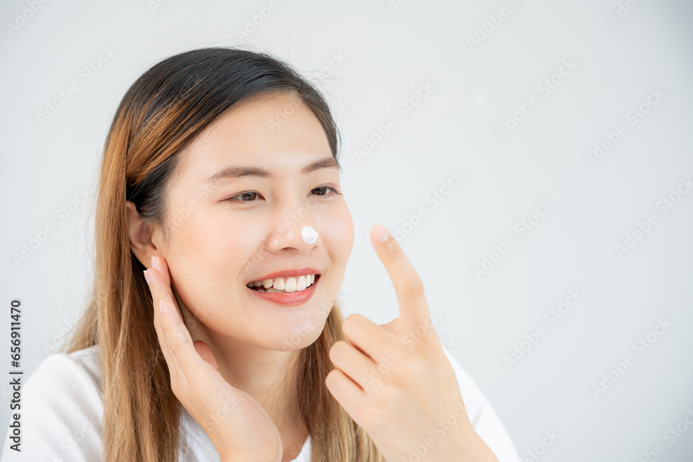Beautiful Asian woman smile use cream touch on nose skin. face of a healthy woman apply cream and makeup. Advertisement for skin cream, anti-wrinkle, baby face, whitening, moisturizer, tighten pores Beautiful Asian woman smile use cream touch on nose skin. face of a healthy woman apply cream and makeup. Advertisement for skin cream, anti-wrinkle, baby face, whitening, moisturizer, tighten pores