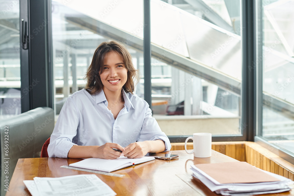 attractive brunette woman in business casual attire smiling and looking at camera, coworking attractive brunette woman in business casual attire smiling and looking at camera, coworking