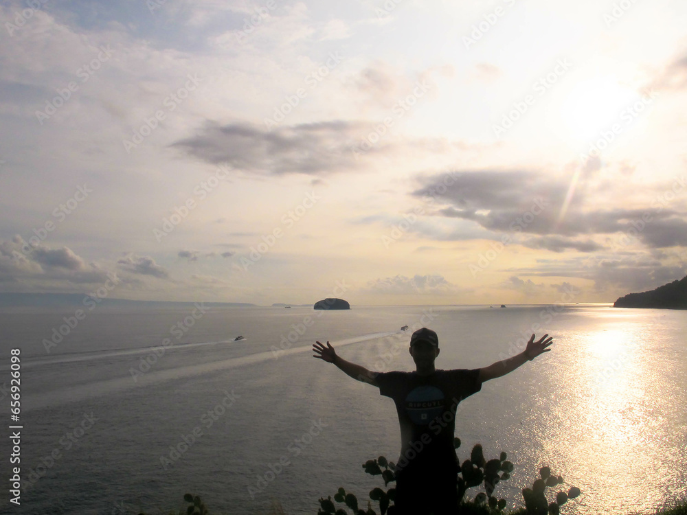 silhouette of a man feel freedom above the beach on sunset silhouette of a man feel freedom above the beach on sunset
