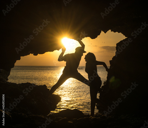 silhouette of a romantic couple on a rock photo