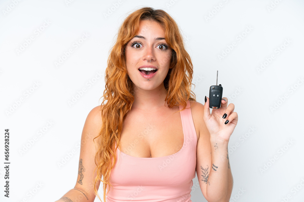 Young caucasian woman holding car keys isolated on white background with surprise and shocked facial expression Young caucasian woman holding car keys isolated on white background with surprise and shocked facial expression