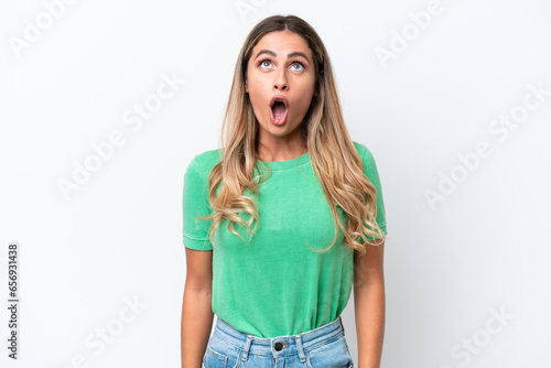 Young Uruguayan woman isolated on white background looking up and with surprised expression © luismolinero