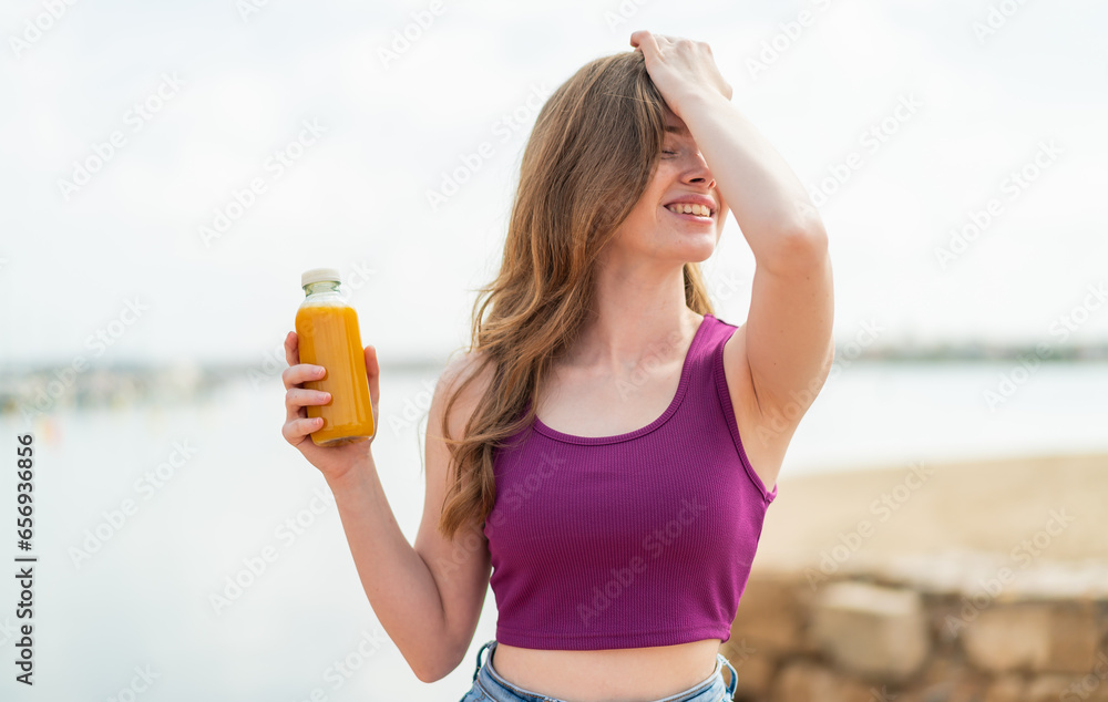 Young redhead girl holding an orange juice at outdoors has realized something and intending the solution Young redhead girl holding an orange juice at outdoors has realized something and intending the solution