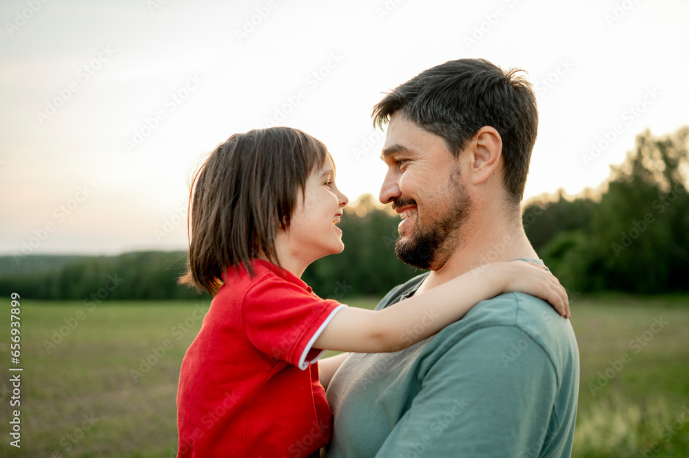 Happy father carrying son in field Happy father carrying son in field