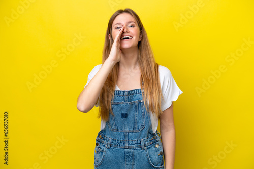 Young caucasian woman isolated on yellow background shouting with mouth wide open