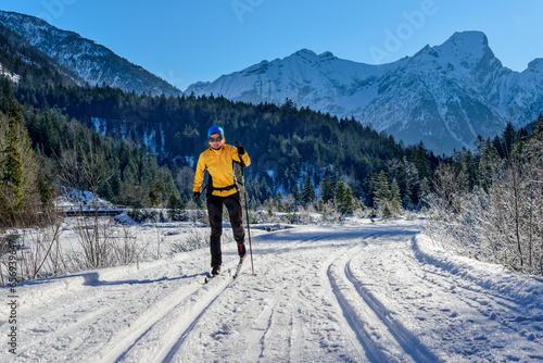 Woman skiing on snowy landscape in front of Karwendel Mountains