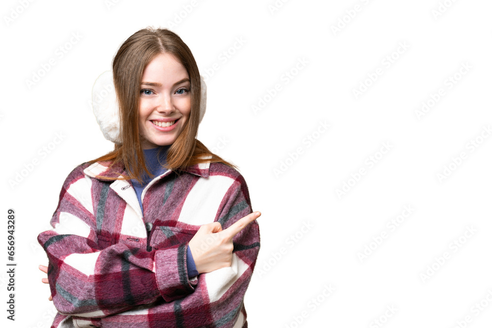 Young pretty woman wearing winter muffs over isolated chroma key background pointing finger to the side Young pretty woman wearing winter muffs over isolated chroma key background pointing finger to the side