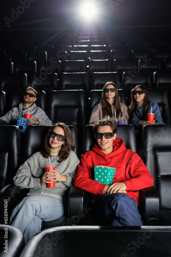 Vertical photo. Friends at the cinema. The premiere of the movie. Popcorn and soda