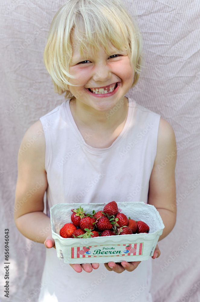 Smiling girl holding fresh strawberries from garden Smiling girl holding fresh strawberries from garden