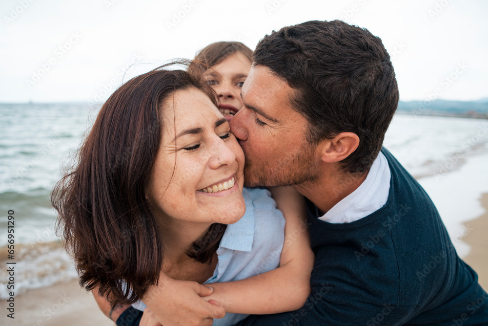 Man embracing and kissing happy woman at beach Man embracing and kissing happy woman at beach