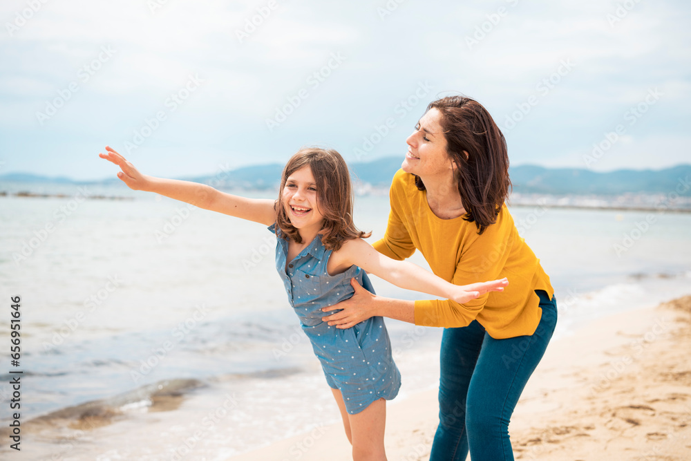 Cheerful mother playing with daughter at beach Cheerful mother playing with daughter at beach