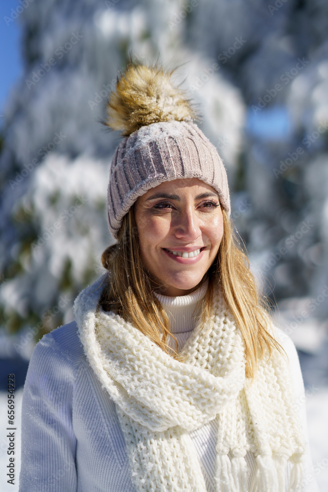 Smiling woman wearing white outfit and cap in winter snow Smiling woman wearing white outfit and cap in winter snow