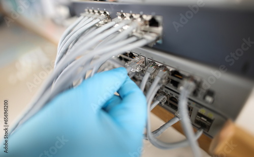Hand of IT engineer technician with lot of internet network cable in wireless system of server room. Internet via cable from router photo