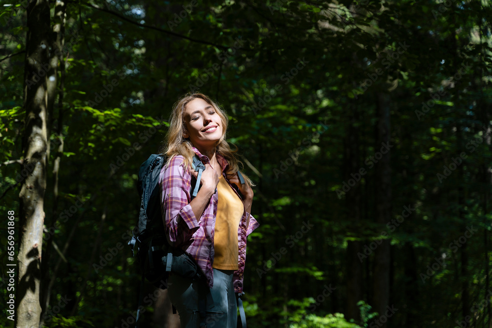 Hiker with eyes closed enjoying sunlight in forest Hiker with eyes closed enjoying sunlight in forest