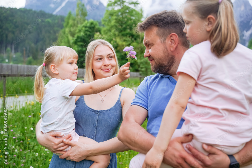 Girl showing flower to father carrying daughter Girl showing flower to father carrying daughter