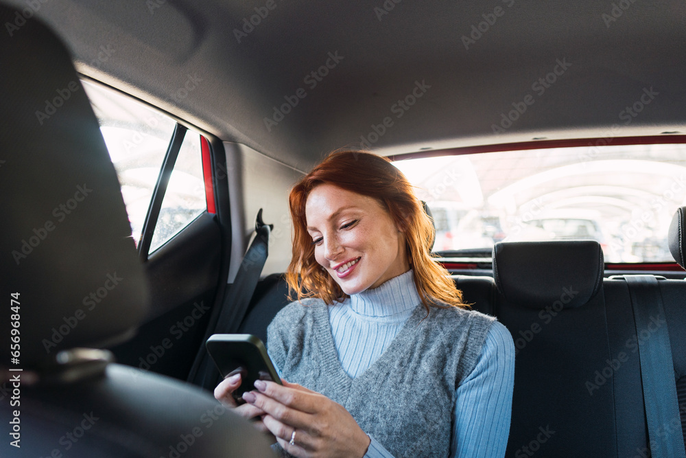Happy woman using smart phone in car