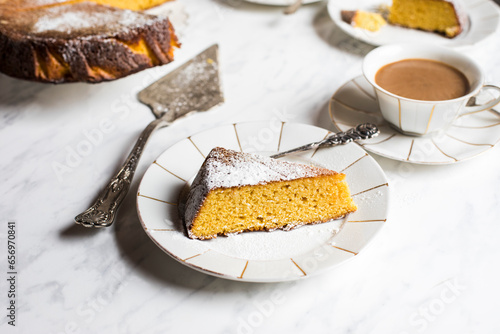 Slice of gluten free orange cake and cup of coffee photo