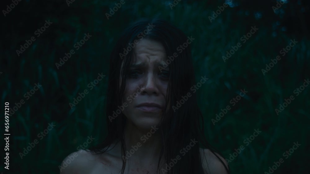 A tired, frightened girl with abrasions in a bloody dress cries looking at the camera A tired, frightened girl with abrasions in a bloody dress cries looking at the camera