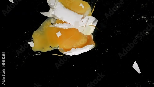 4K - Egg falls and breaks onto glass. Slow-mo directly above camera