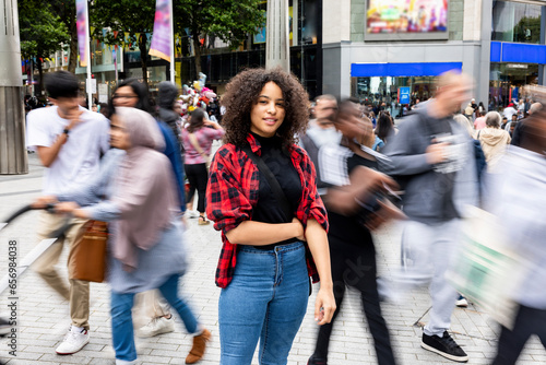 Smiling woman standing amidst crowd in city photo