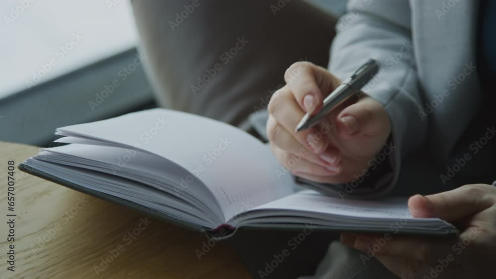 Close up shot of hands of therapist taking notes and writing them down in notebook Close up shot of hands of therapist taking notes and writing them down in notebook