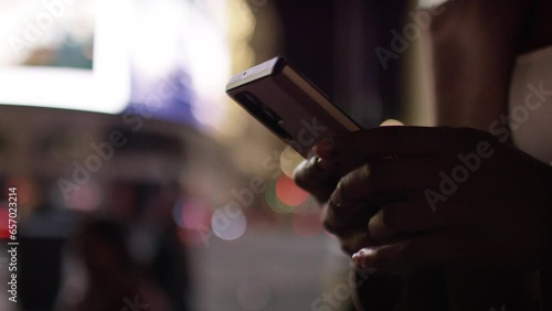 Close up of female hands using a smart phone in the city at night