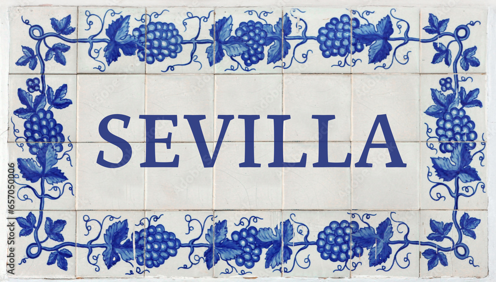 Fototapeta premium Sevilla (Seville in Spanish) on Frame of Azulejos (name of Spanish tiles) with blue bunches of grapes