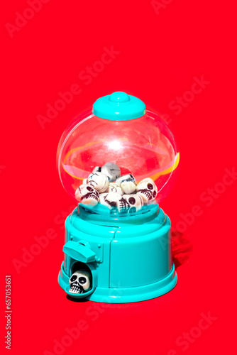 Small skulls in vending machine on red background photo