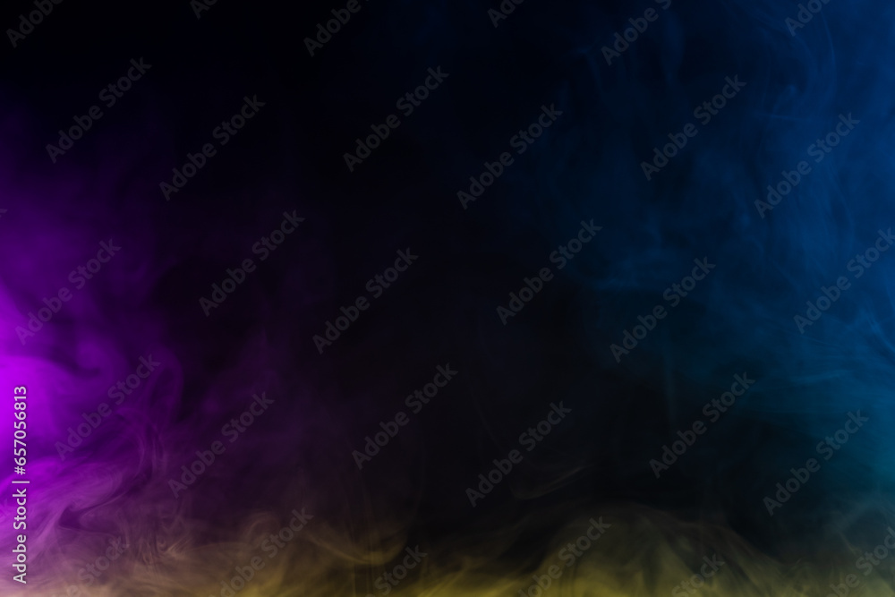 Blurred photo texture of colored smoke on a black background.