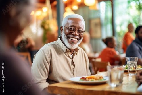 Happy afro american man sitting at table with food