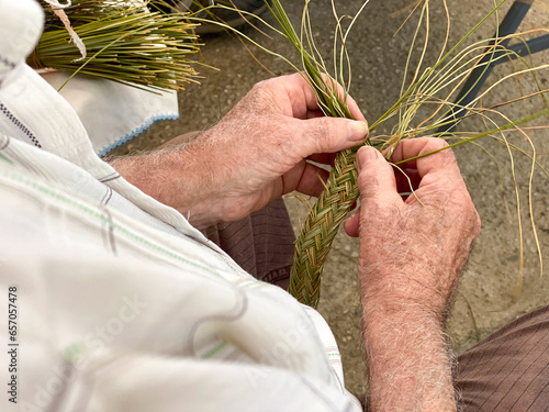 Tableau sur toile Male hands close up working on basketry with esparto grass