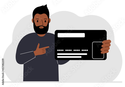 A man holds a large plastic credit card in his hand.